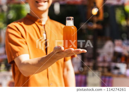 Happy man hand holding a bottle of orange juice 114274261