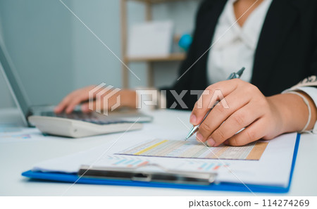 Business woman people use computers and paper documents to analyze business and manage corporate information. Business analysis with charts, indicators, and KPIs to improve organizational performance. 114274269