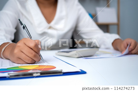 Business woman people use computers and paper documents to analyze business and manage corporate information. Business analysis with charts, indicators, and KPIs to improve organizational performance. 114274273