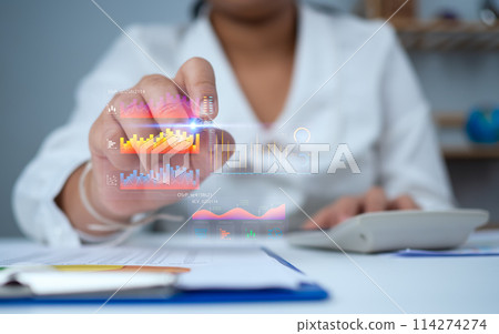 Business woman uses a pen to point at a virtual graph to analyze business and manage corporate data, business analytics with charts, metrics and KPIs to improve organizational performance. 114274274