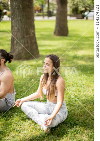 Young couple doing yoga outdoors Young couple doing yoga outdoors 114274821