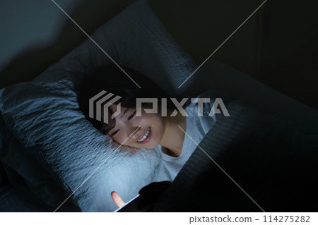Young woman spending her time in bed Young woman spending her time in bed 114275282