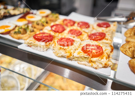 Various hot dishes . Glass Showcase in a buffet or self-service restaurant. 114275431