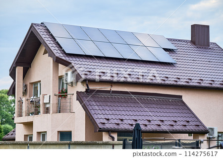 House with solar panels on rooftop for generating electricity through photovoltaic effect. Home with solar power system on roof. Concept of alternative energy, autonomy, power sustainable resources. House with solar panels on rooftop for generating electricity through photovoltaic effect. Home with solar power system on roof. Concept of alternative energy, autonomy, power sustainable resources. 114275617
