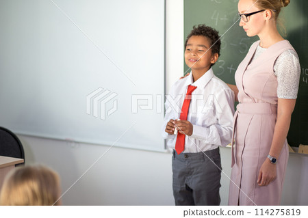 boy solving addition and subtraction on board. schoolboy writing solution of mathematical operation boy solving addition and subtraction on board. schoolboy writing solution of mathematical operation 114275819