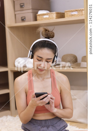 Young Sport Women look at laptop online trainer home fitness workout exercise in living room. Woman using laptop on floor in sportswear arms stretching body weight traning. Healthy lifestyle concept Young Sport Women look at laptop online trainer home fitness workout exercise in living room. Woman using laptop on floor in sportswear arms stretching body weight traning. Healthy lifestyle concept 114276031