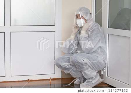 Exhausted doctor in protective medical clothing during the coronavirus epidemic. 114277152