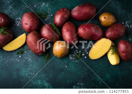 Raw uncooked potato on green table Raw uncooked potato on green table 114277955