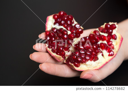 Purified pomegranate fruit in a female hand 114278682
