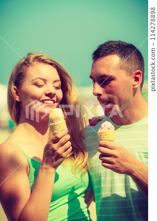 Man and woman eating ice cream on beach 114278898