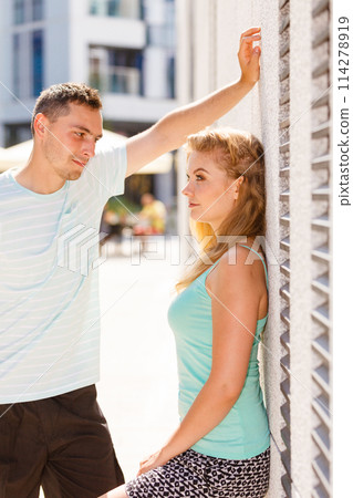 Man flirting with girl on city street 114278919