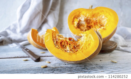 Pumpkin slices with seeds on wooden background, selective focus 114280252