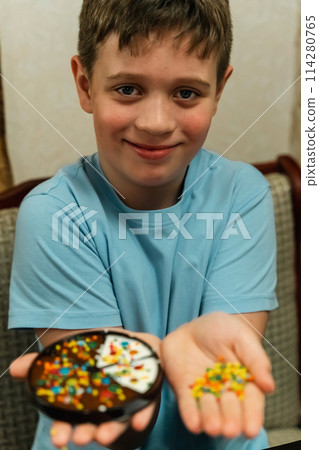 Boy proudly holds a bowl of colorful sprinkles 114280765