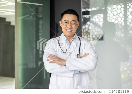 Portrait of Asian successful head doctor of clinic, man in white medical coat with stethoscope smiling and looking at camera with crossed arms. Portrait of Asian successful head doctor of clinic, man in white medical coat with stethoscope smiling and looking at camera with crossed arms. 114281519