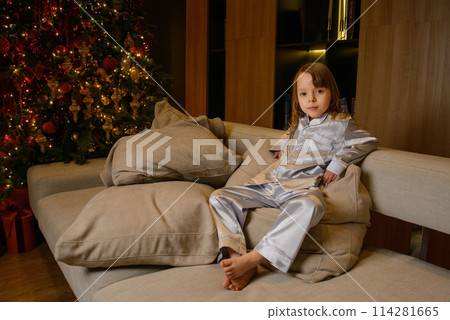 A happy family poses in pajamas in New Year's locations. A happy family poses in pajamas in New Year's locations. 114281665