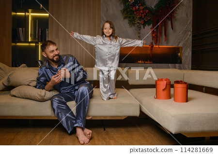 A happy family poses in pajamas in New Year's locations. 114281669