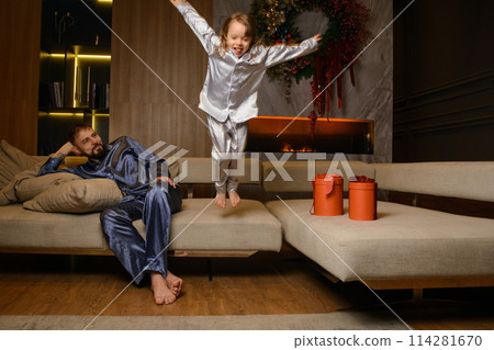 A happy family poses in pajamas in New Year's locations. 114281670