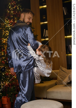 A happy family poses in pajamas in New Year's locations. 114281671