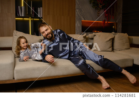 A happy family poses in pajamas in New Year's locations. A happy family poses in pajamas in New Year's locations. 114281681