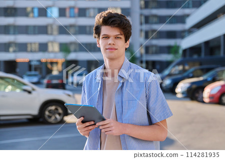 Young handsome male using digital tablet on city street 114281935