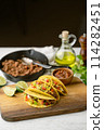 yellow hard shell tacos  on cutting board 114282451