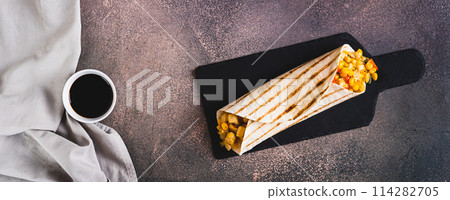 Appetizing burrito in a tortilla made of chicken, corn and peppers on a board top view web banner Appetizing burrito in a tortilla made of chicken, corn and peppers on a board top view web banner 114282705