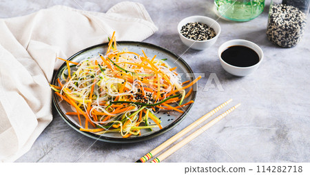 Appetizing salad of funchose, carrots, cucumber and sesame on a plate web banner Appetizing salad of funchose, carrots, cucumber and sesame on a plate web banner 114282718