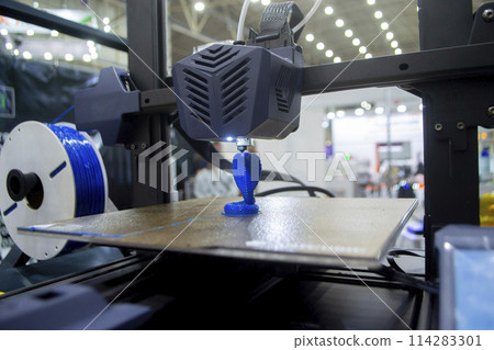 3D printer working close-up. 3D printer prints a model from molten yellow plastic close-up. 3D printer printing object. New modern prototyping technologies. Additive progressive high-tech technology. 3D printer working close-up. 3D printer prints a model from molten yellow plastic close-up. 3D printer printing object. New modern prototyping technologies. Additive progressive high-tech technology. 114283301