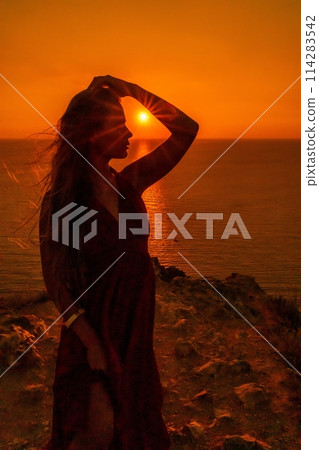 Woman sunset sea red dress, portrait happy beautiful sensual woman in a red long dress posing above the sea on sunset. 114283542