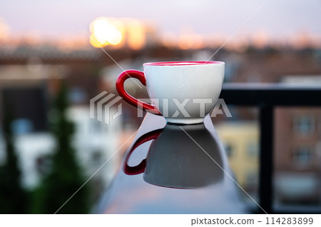 Small cup of coffee reflecting in a wet black surface with a city background, Belgium Small cup of coffee reflecting in a wet black surface with a city background, Belgium 114283899