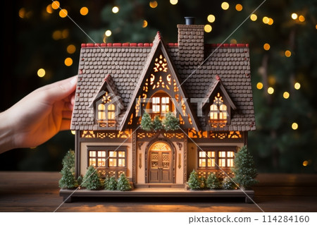 Gingerbread house with lights on wooden table,Christmas lights background Gingerbread house with lights on wooden table,Christmas lights background 114284160