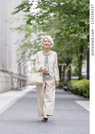 Smiling senior woman walking in the city 114284237