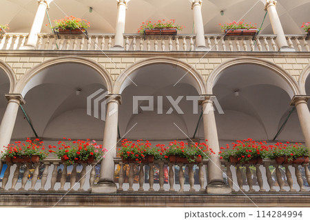 [Ukraine] Stone arches and red flower planters on each floor of an Italian-style courtyard in the old town of Lviv 114284994