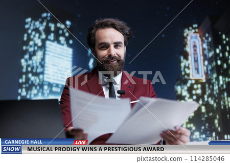 Newscaster talks about awarded artist, famous singer receiving important career award after performing at city hall. International tv host working on entertainment segment late at night. 114285046