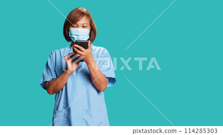 Worried nurse delivering bad news to patient in telemedicine phone chat. Clinic employee overthinking upsetting message for hospital visitor, isolated over blue studio background 114285303