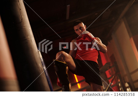 Practicing low kick with punching bag 114285358