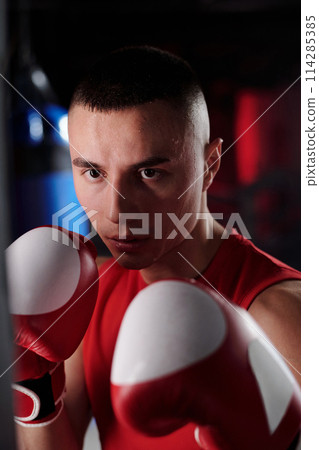 Boxer standing in front of punching bag 114285385