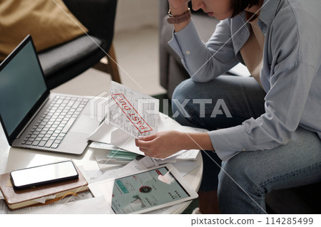 Hand of troubled woman with overdue bill 114285499