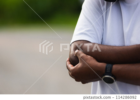 Close up Asian young sport runner black man wear watch he having elbow pain and use hands joint hold elbow while exercising at the outdoor street health park, healthy exercise Injury from workout Close up Asian young sport runner black man wear watch he having elbow pain and use hands joint hold elbow while exercising at the outdoor street health park, healthy exercise Injury from workout 114286092