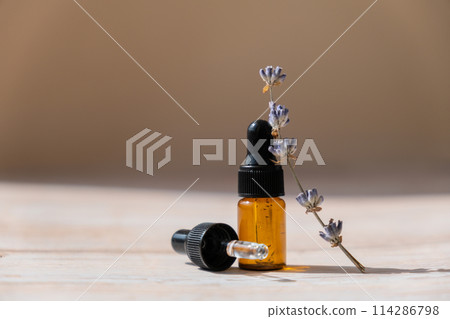 Glass bottle dropper with dried lavender flowers. Wild harvested essential oil beauty product. Organic herbs skincare ingredient environmentally friendly 114286798