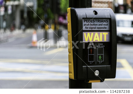 Crosswalk button for pedestrian with light warning on a defocused background, London, UK 114287238