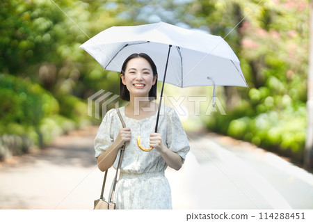 拿著遮陽傘的一個少婦 拿著遮陽傘的一個少婦 114288451