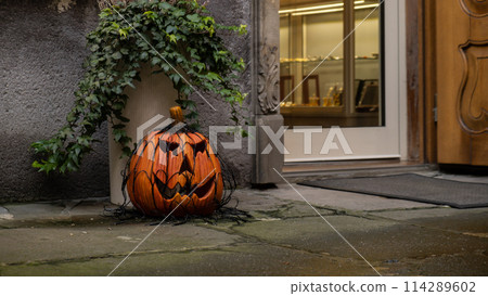 Exterior Beautiful atmospheric halloween scary grin drawn pumpkins decorated on porch. Autumn leaves and fall flowers celebration holiday Thanksgiving October season 114289602