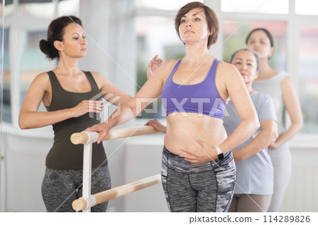 Adult woman teacher correcting beginning dancers 114289826