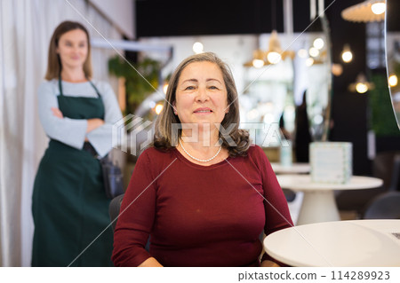 Smiling elderly female client of hairdressing salon after haircut Smiling elderly female client of hairdressing salon after haircut 114289923