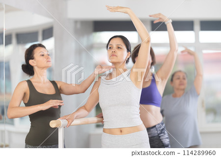 Choreographer coach teaches amateur students to keep their heads straight during ballet lesson 114289960