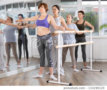 Woman mastering second position in beginner ballet class Woman mastering second position in beginner ballet class 114290120