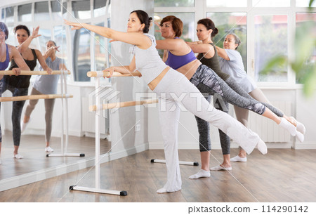 Women ballet lovers learn to perform arabesque pose in choreography studio Women ballet lovers learn to perform arabesque pose in choreography studio 114290142