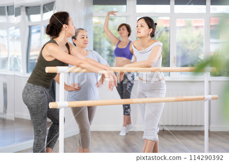 Women socializing at ballet barre before starting amateur class Women socializing at ballet barre before starting amateur class 114290392