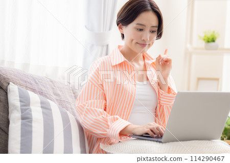 A woman watching a personal computer A woman watching a personal computer 114290467